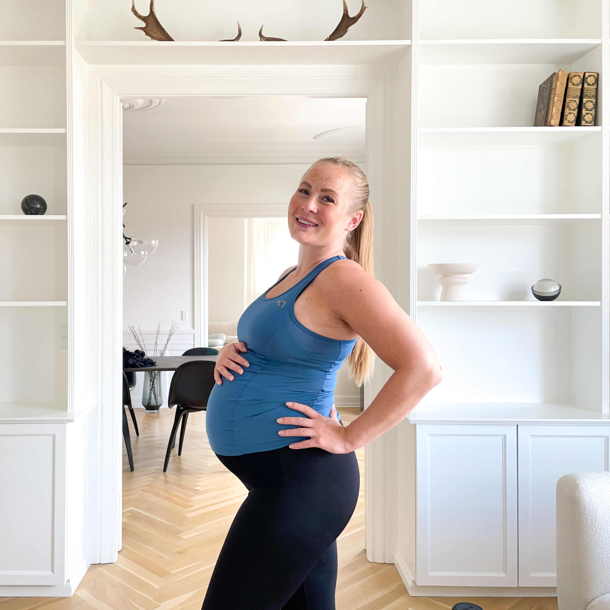 Gravid kvindelig træner smiler