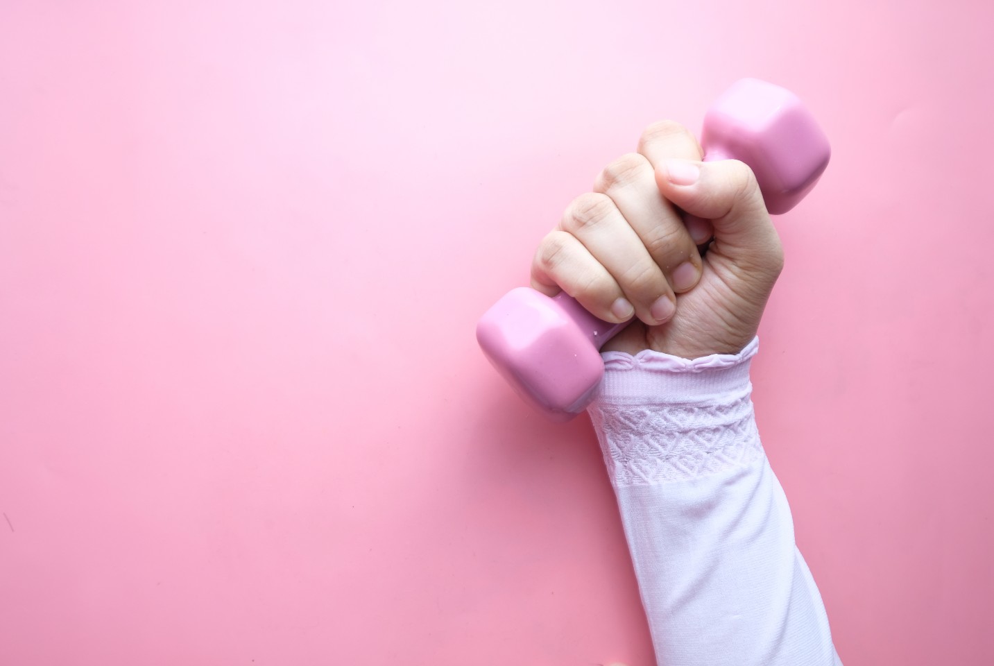 Kvinde holder en lyserød håndvægt