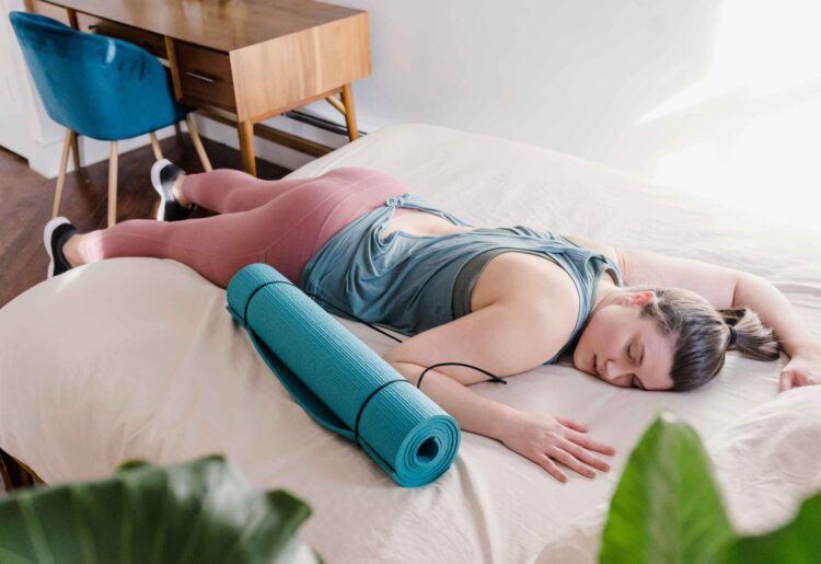 Træt kvinde ligger på sengen