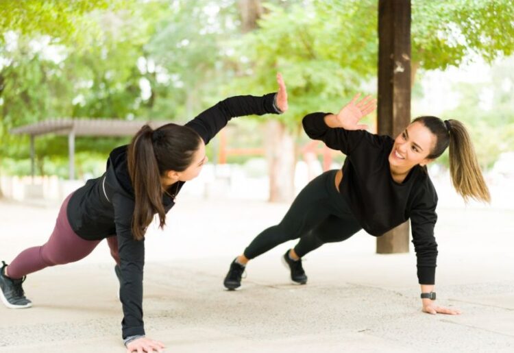 To kvinder står i planke og giver high five
